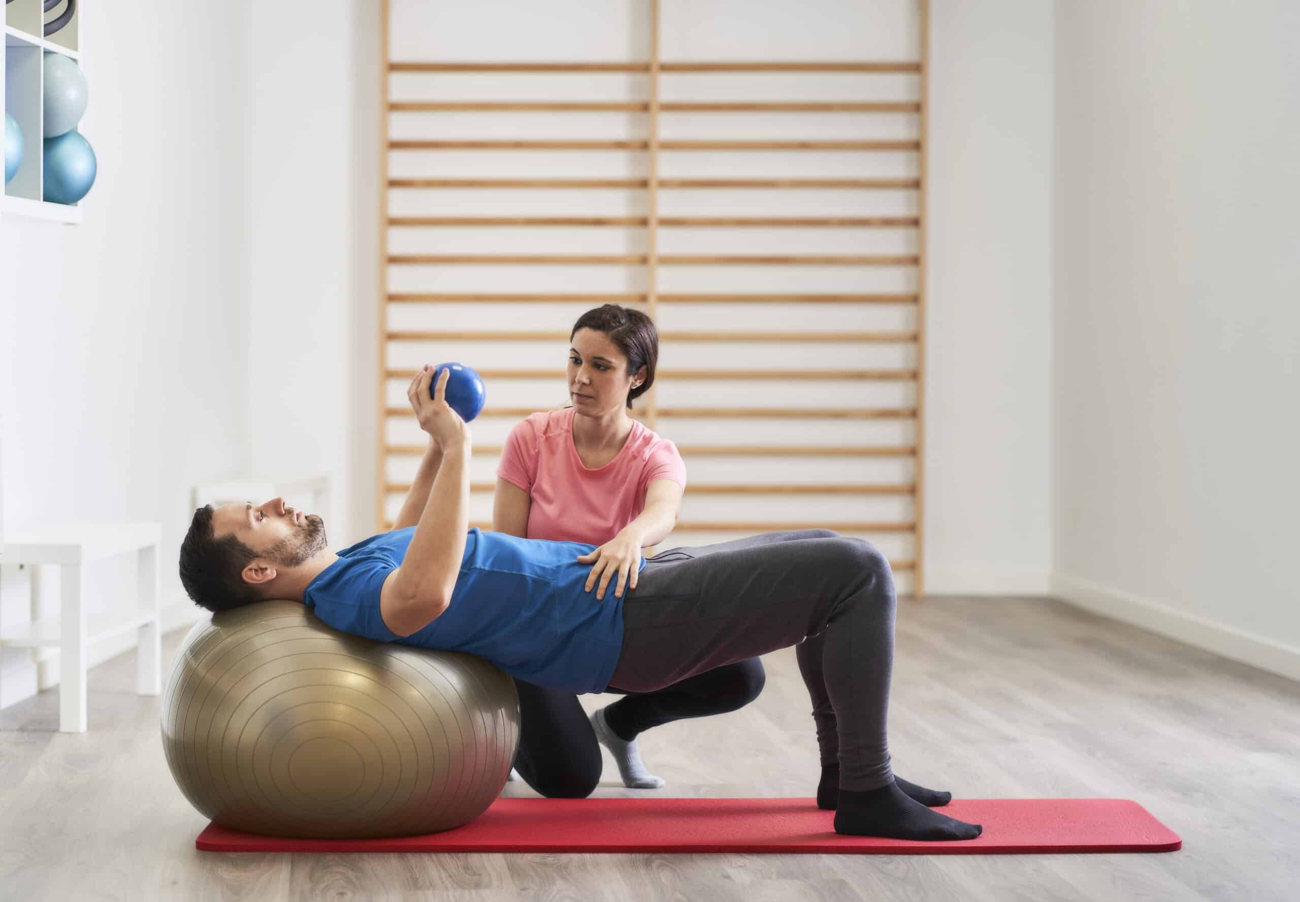 a young woman instructing a man on the correct posture for exercising